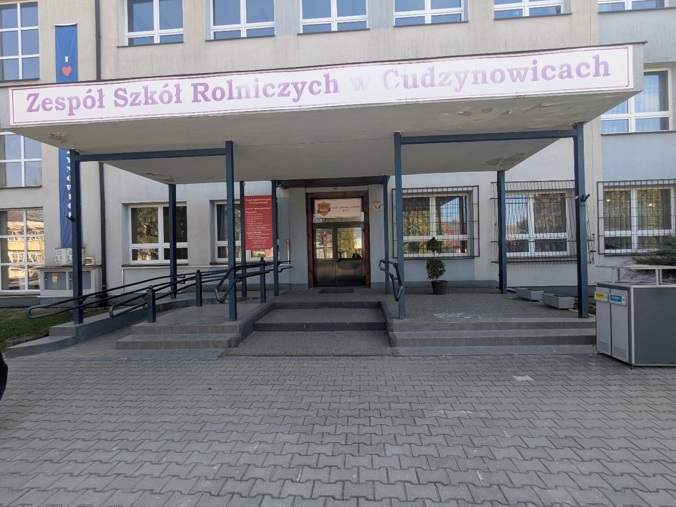 Na zdjęciu widoczny jest budynek i wejście do Zespołu Szkół Rolniczych w Cudzynowicach.