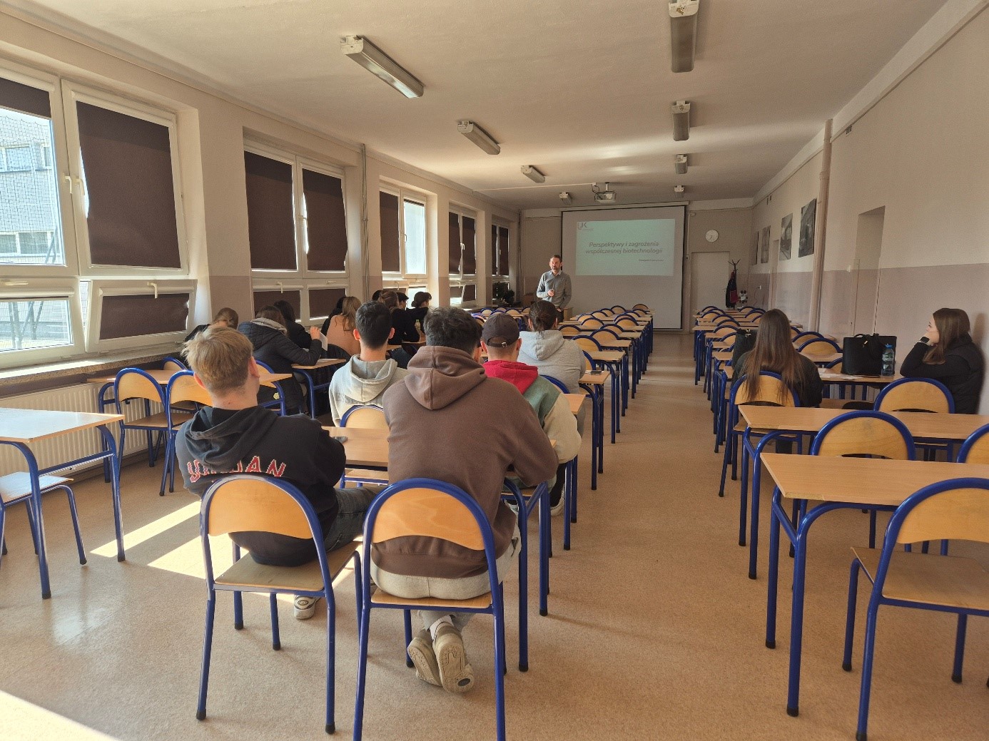 Na zdjęciu sala lekcyjna, w której prowadzona jest prezentacja na temat kierunku rolnictwo. Na zdjęciu znajduje się młodzież i prowadzący zajęcia.