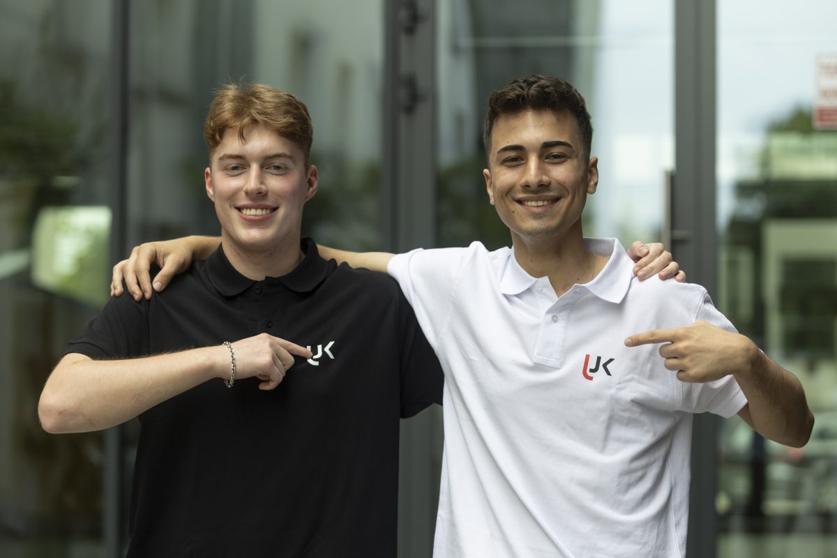 Dwaj studenci na tel budynku uniwersyteckiego