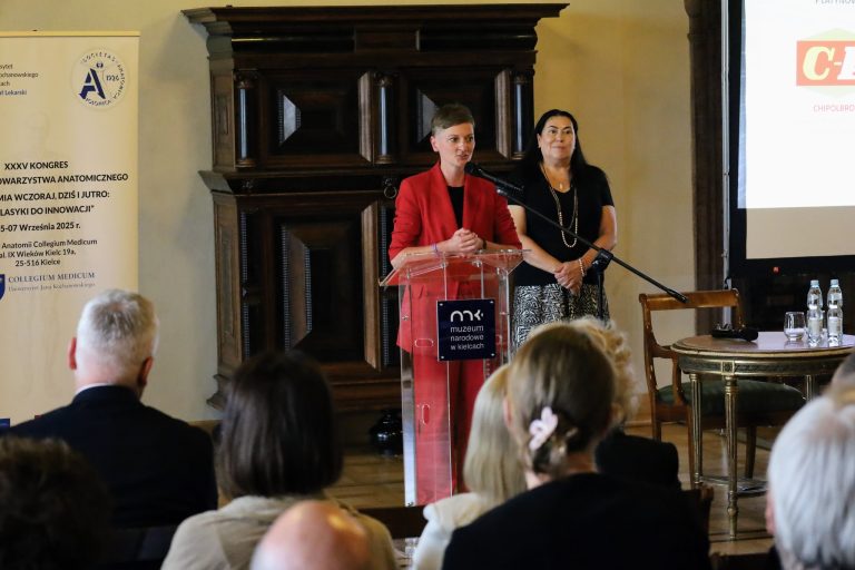 Prezydentka Kielc - Agata Wojda w czerwonym garniturze wygłasza przemówienie.