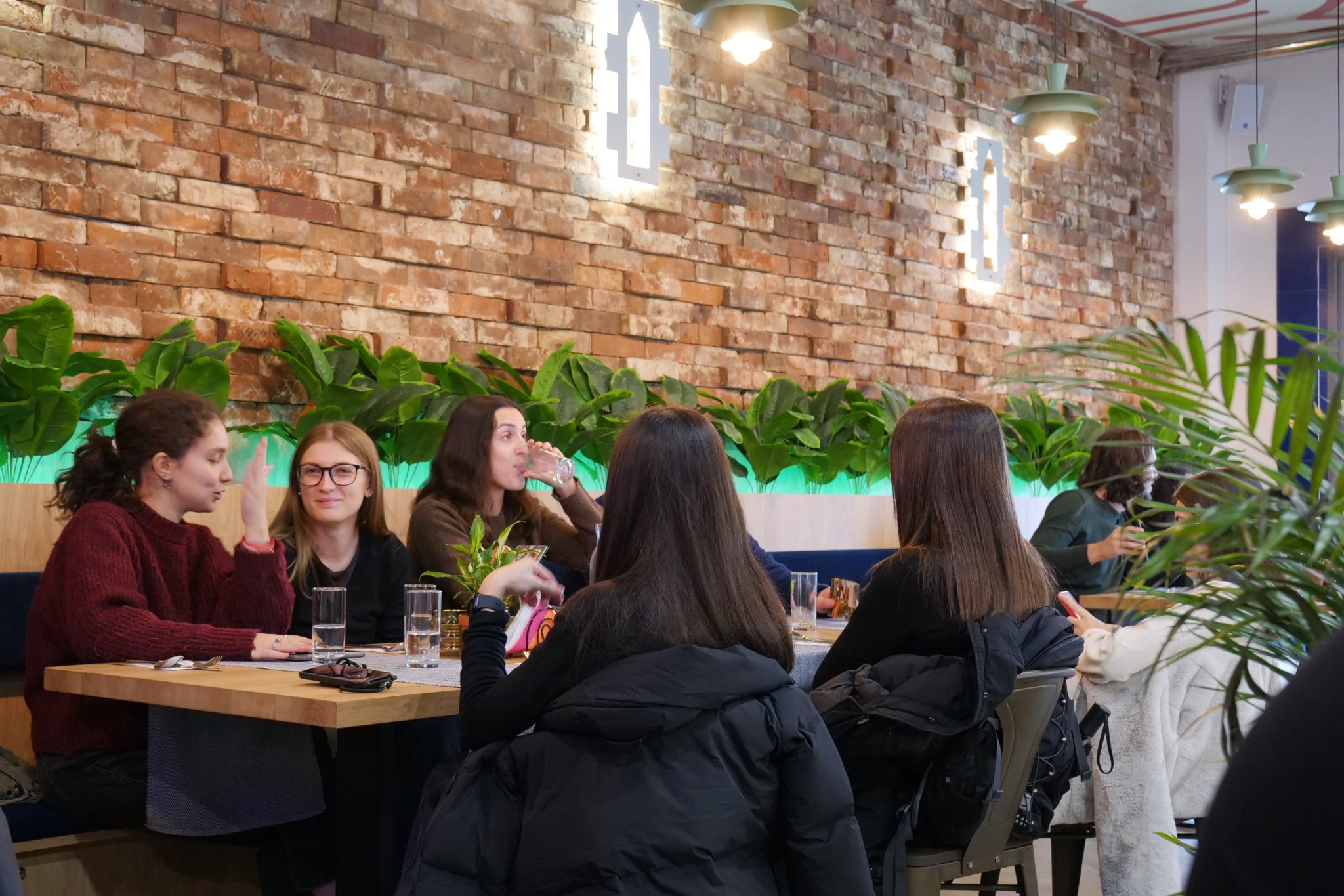 Grupa studentów siedzi w restauracji przy stole.