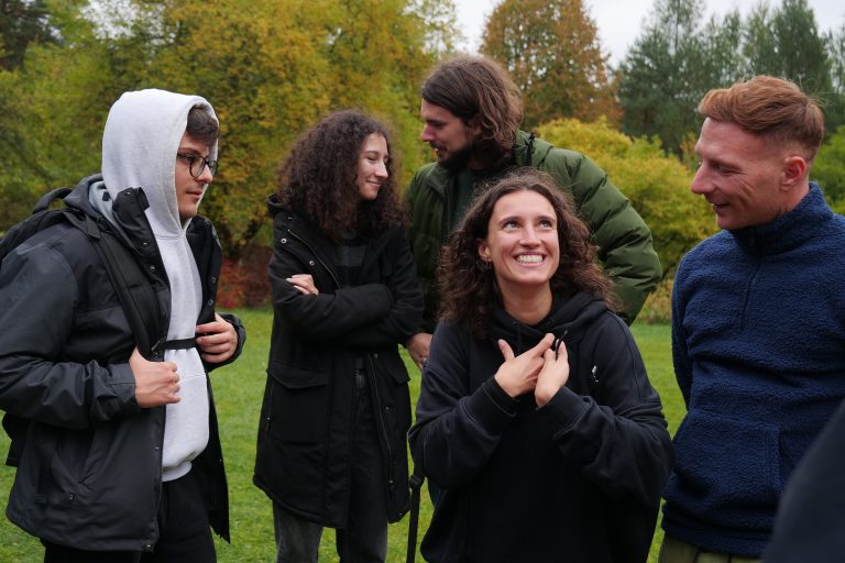 Grupa studentów wymiany międzynarodowej uśmiechająięi rozmawiają.