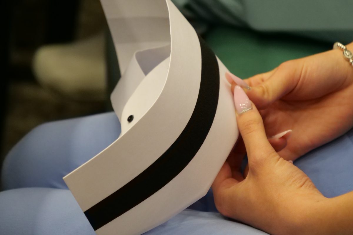 czepek pielęgniarski w dłoniach