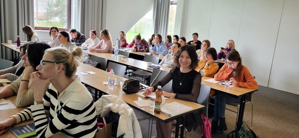 Na zdjęciu widać salę ćwiczeniową oraz Uczestników kursu. Na pierwszym planie widać naszego pracownika dydaktycznego dr Kamilę Sobaś, która pozuje do zdjęcia.