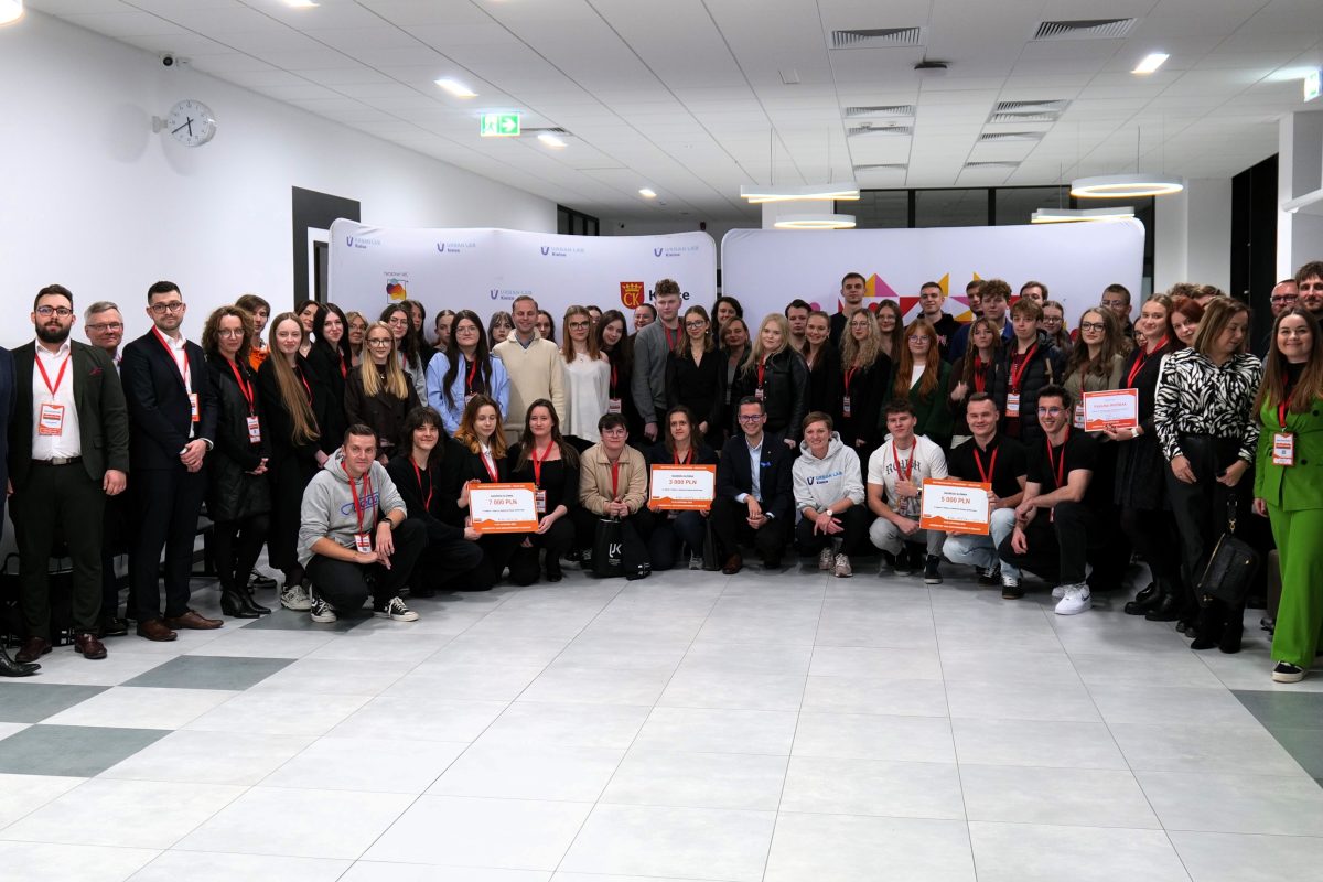 Uczestniccy i organizatorzy projektu Ideaton pozują do zdjęcia ustawieni w półokrąg