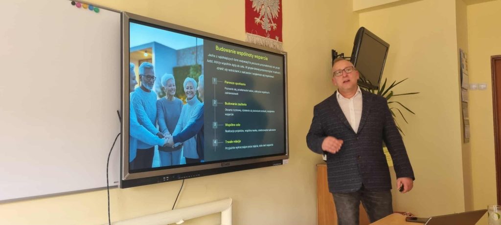 Prowadzący na tle jednego ze slajdów prezentacji