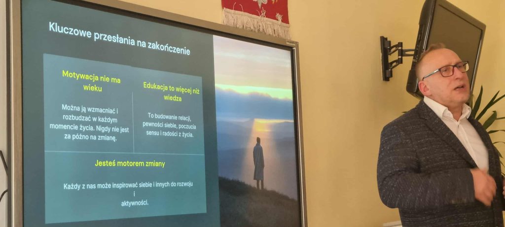 Prowadzący na tle jednego ze slajdów prezentacji