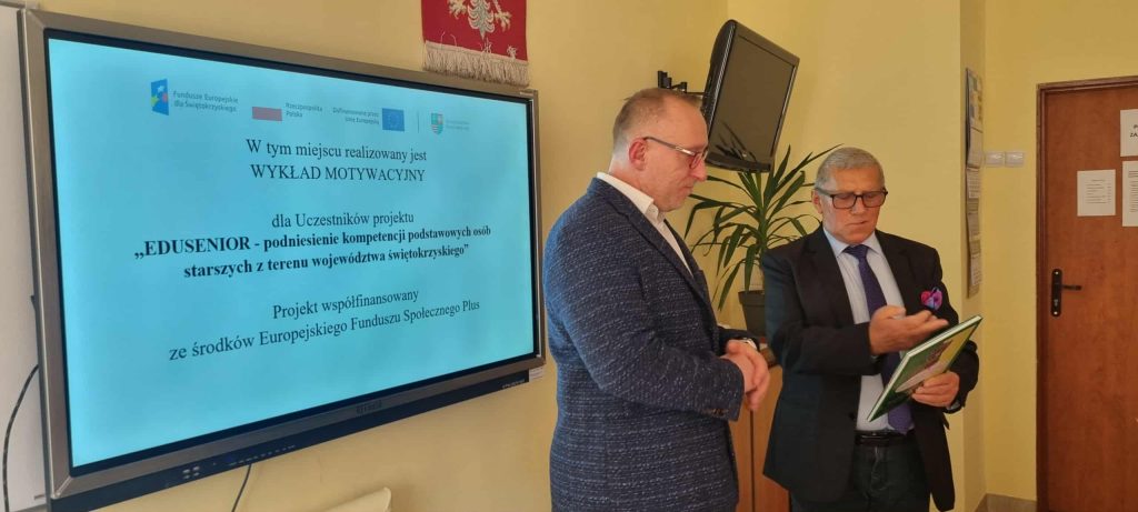 Prowadzący w towarzystwie , w tle plansza tytułowa wykładu