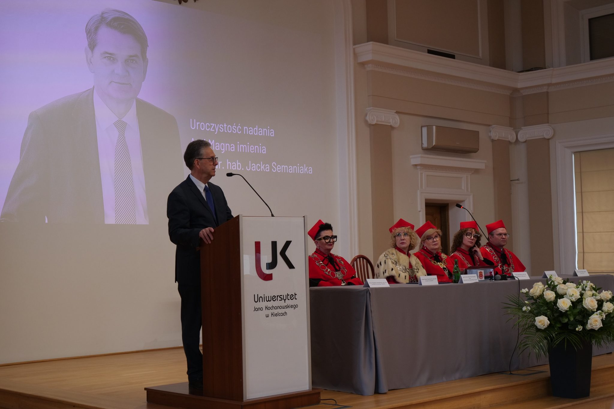 Uroczystość w auli. W tle tablica pamiątkowa ze zdjęciem prof. Jacka Semaniaka.