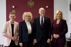 Kolejne ujęcie pamiątkowej fotografii tej samej grupy w gabinecie.