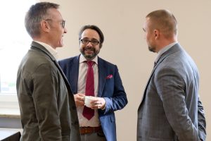 rzech uśmiechniętych mężczyzn dyskutujących podczas nieformalnej przerwy.